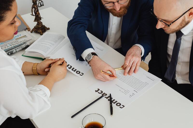 Business professionals reviewing a document together at an office desk during a consultation (representative stock photo)